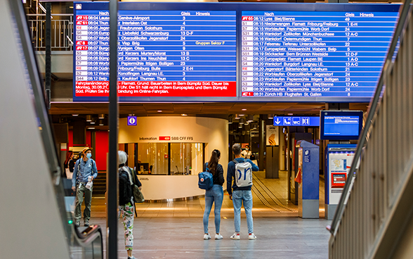Halle des Bahnhofs Bern mit Anzeigetafel zu den nächsten Abfahrten.